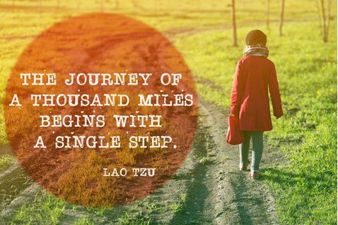 A woman in a red coat is walking down a dirt road.