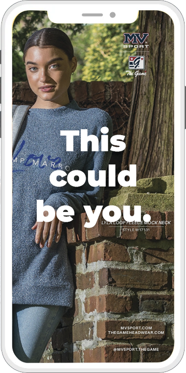 A woman is standing next to a brick wall on a cell phone.