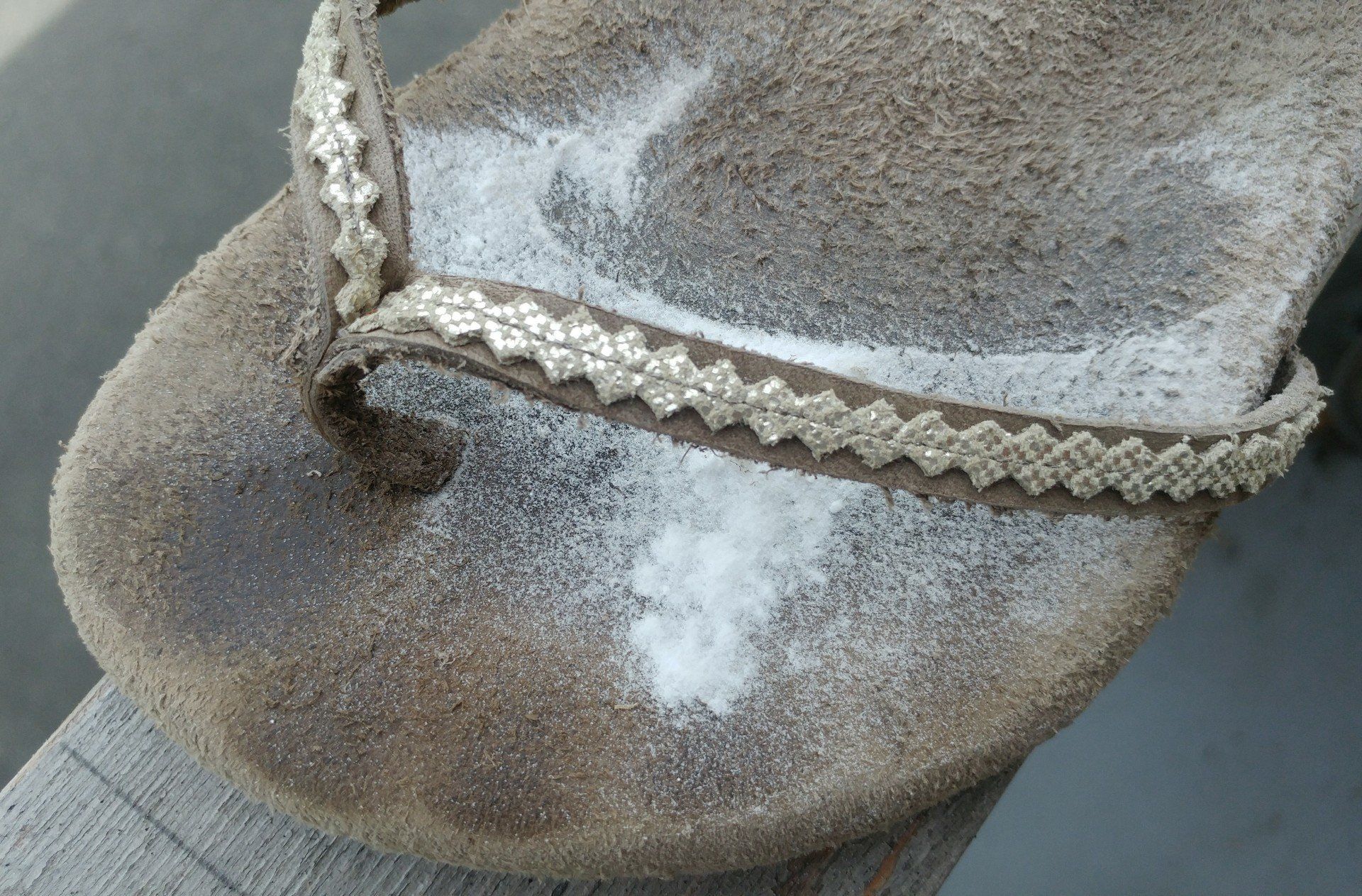 toe of beige and gold diamond back suede vitalsole thong flip-flop sandal with toe marks and baking soda on it