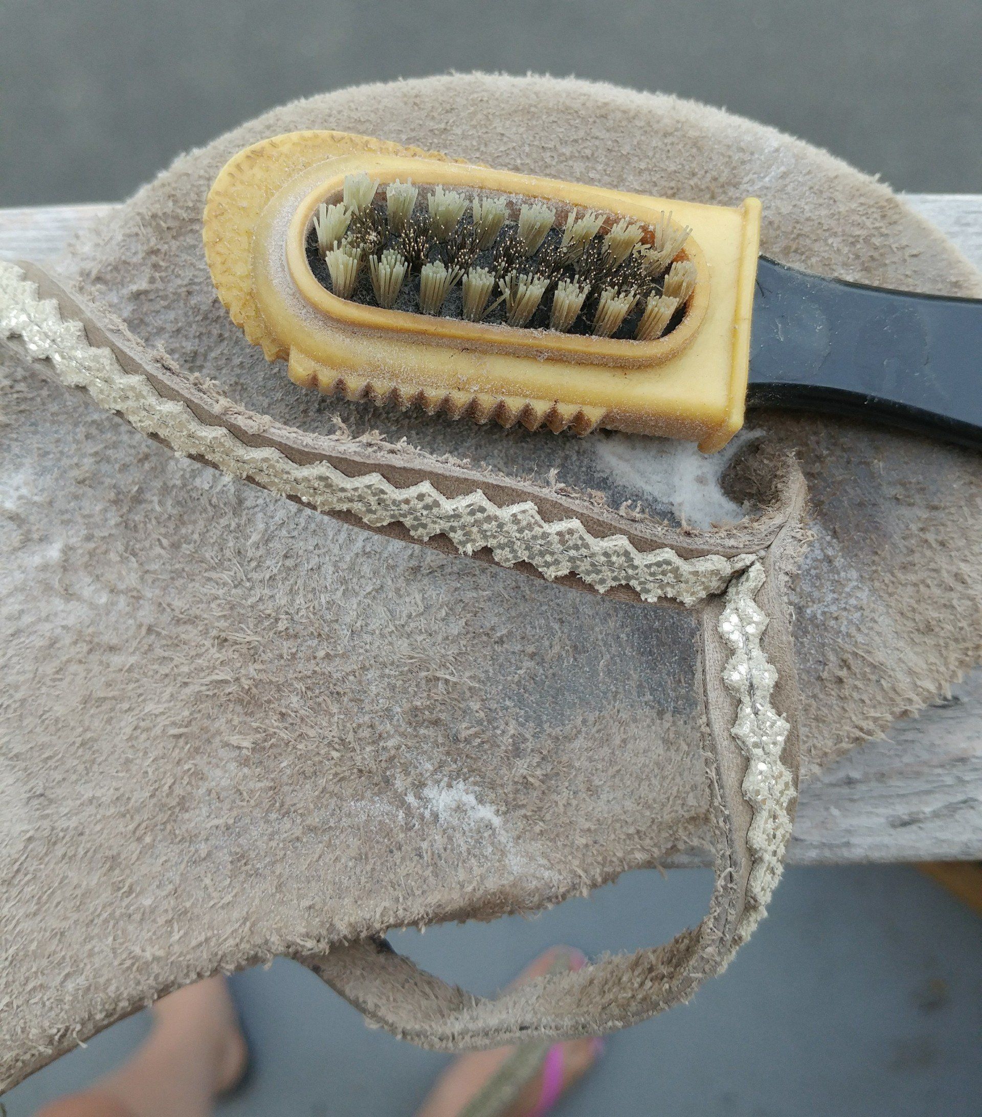 image looking down at vitalsole tan and gold suede flip-flop shoe with wire bristle suede brush
