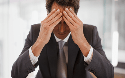 man pressing his forehead