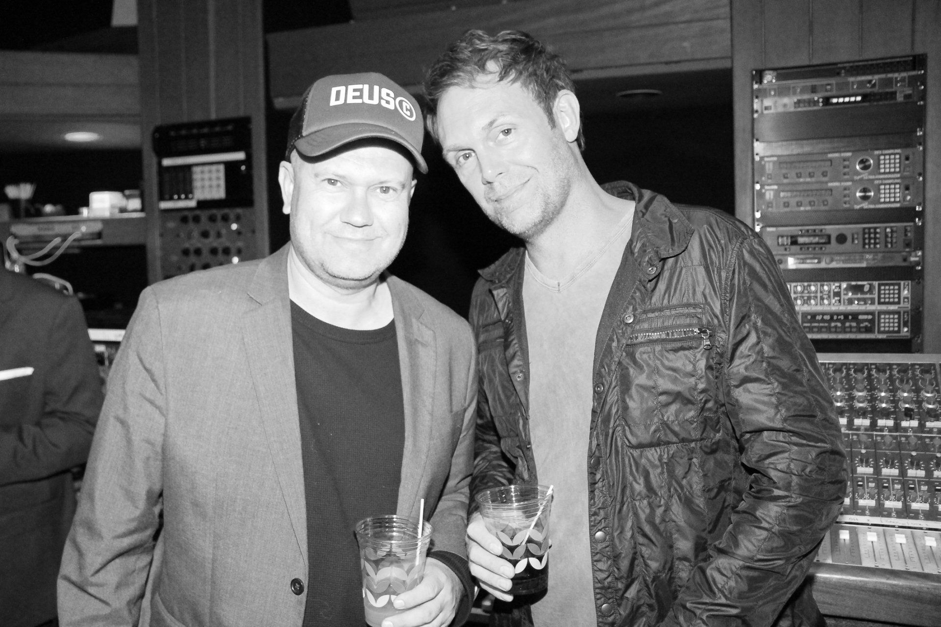 Two men are standing next to each other and one of them is wearing a deus hat.