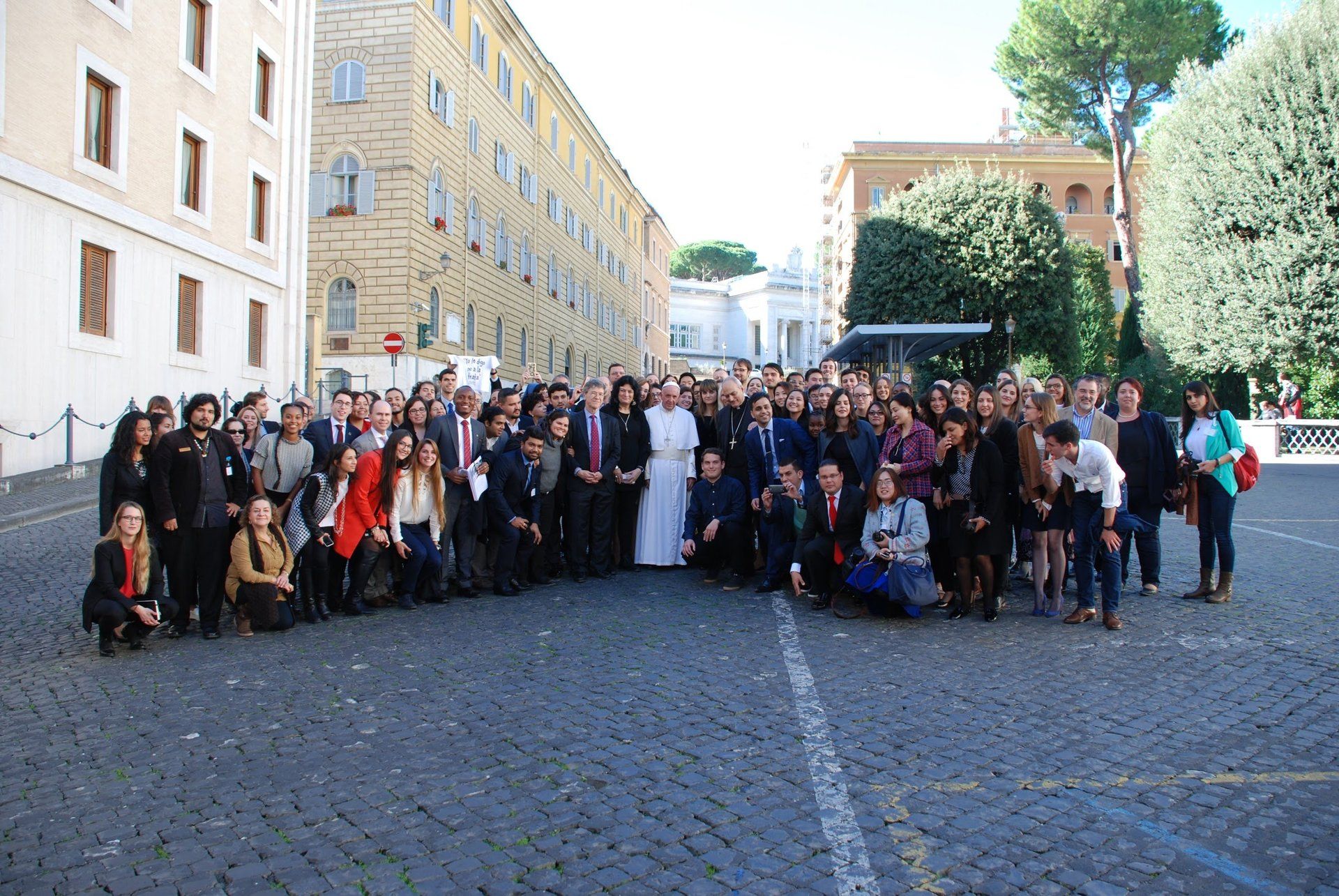A large group of people are posing for a picture in front of a building