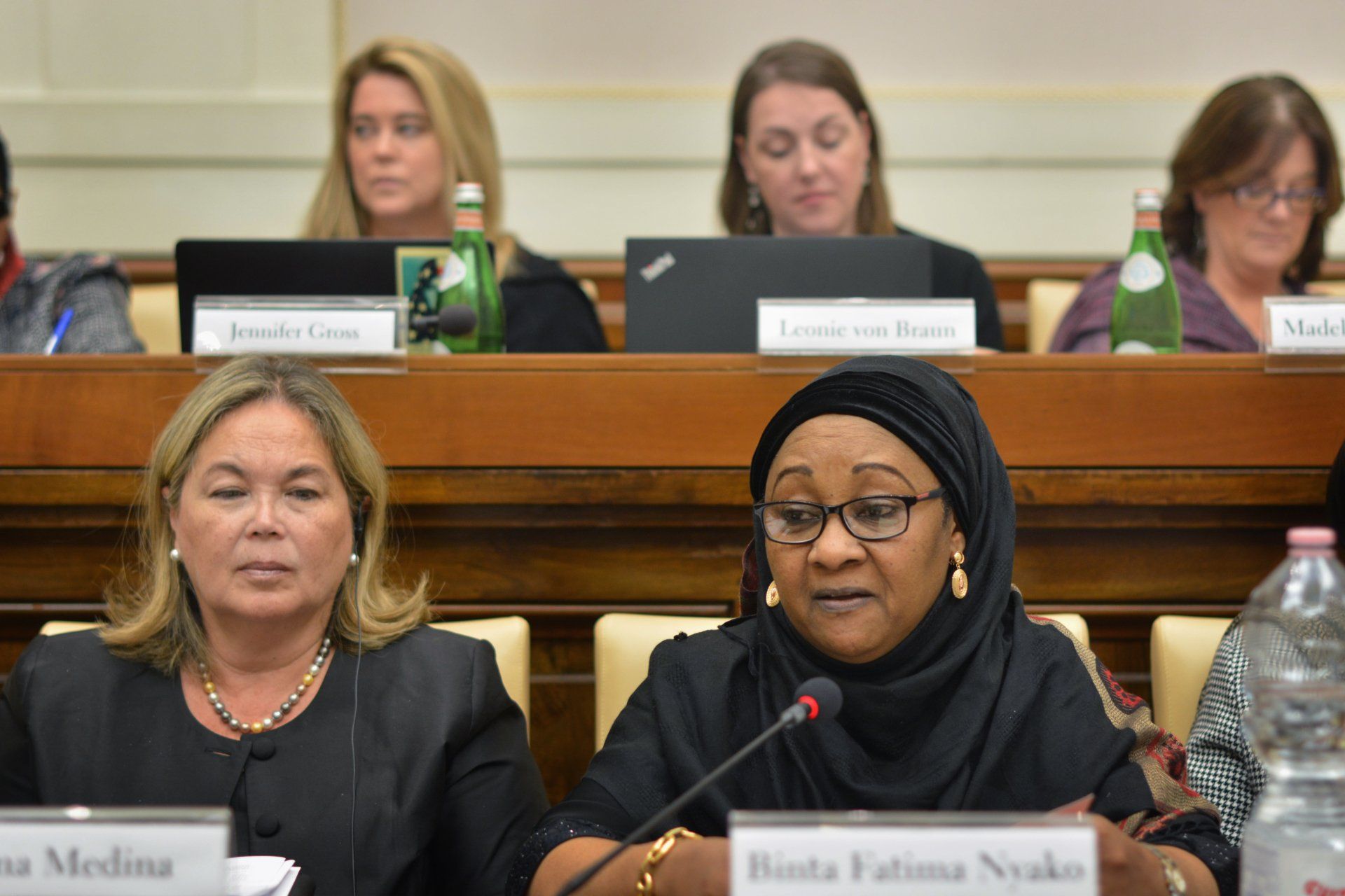 A woman sitting at a table with a name tag that says fatima