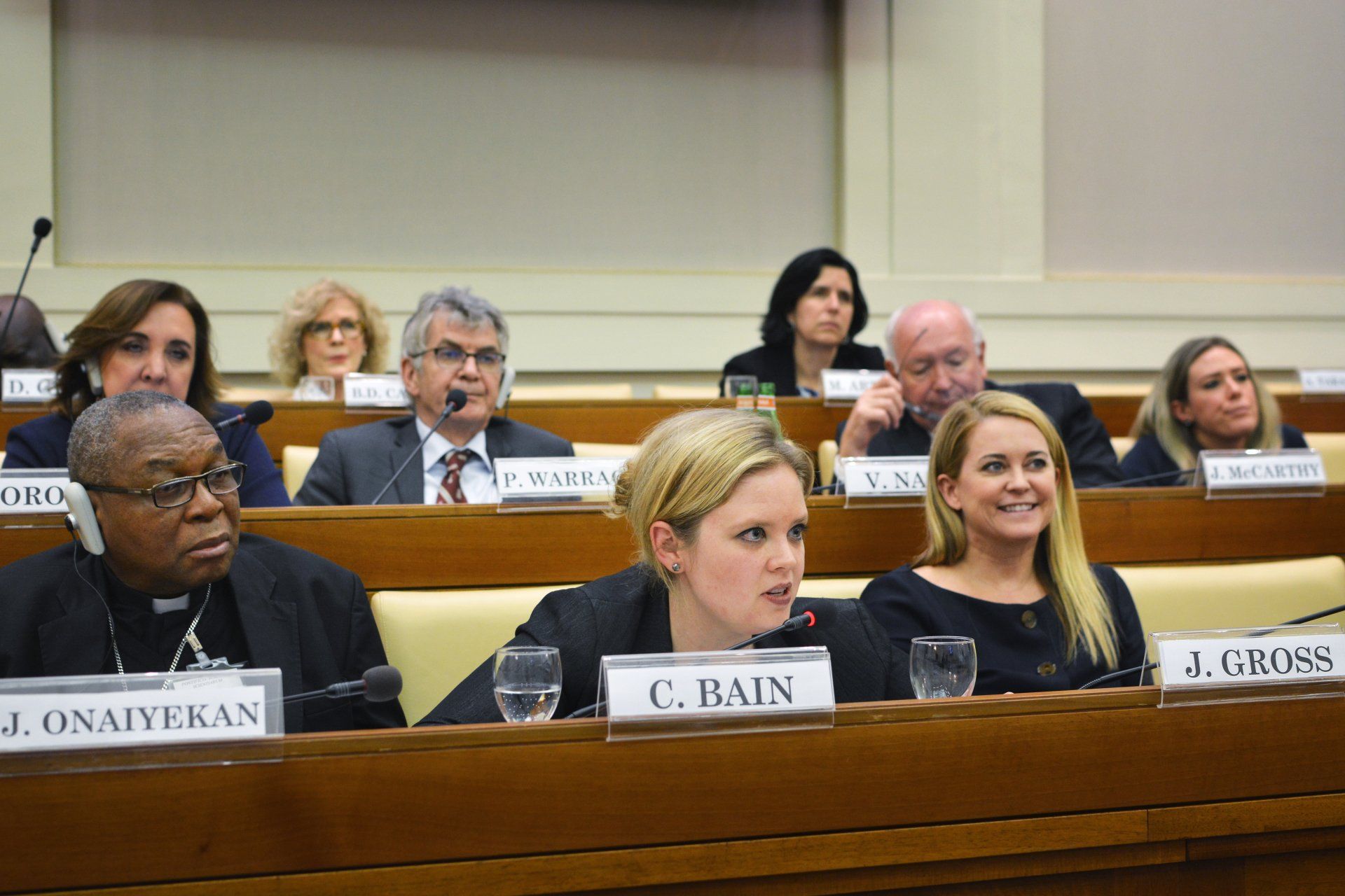 A group of people are sitting at a table with a sign that says c. bain