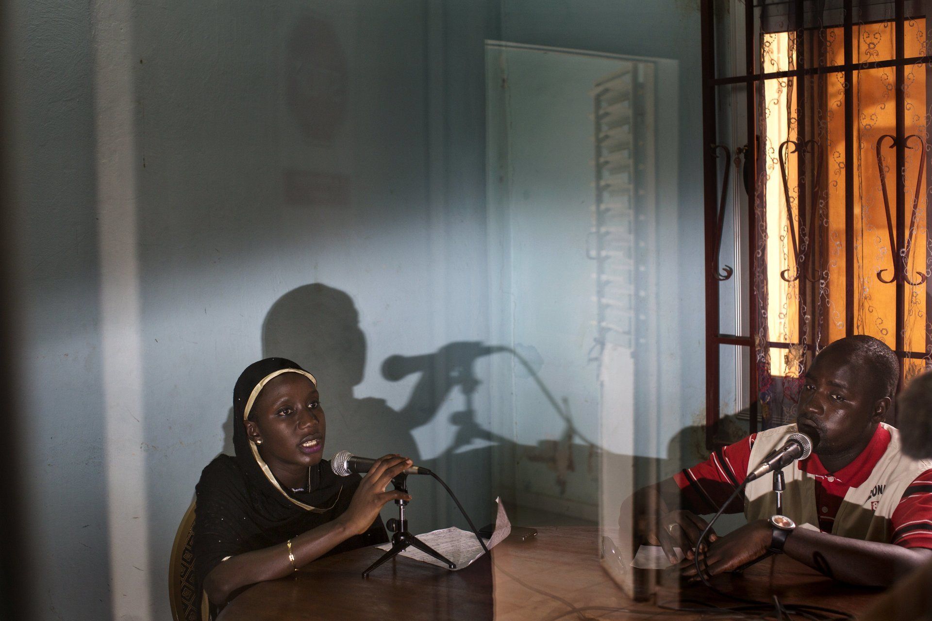 VII Foundation: A women and a man talking into a mic in a blue room