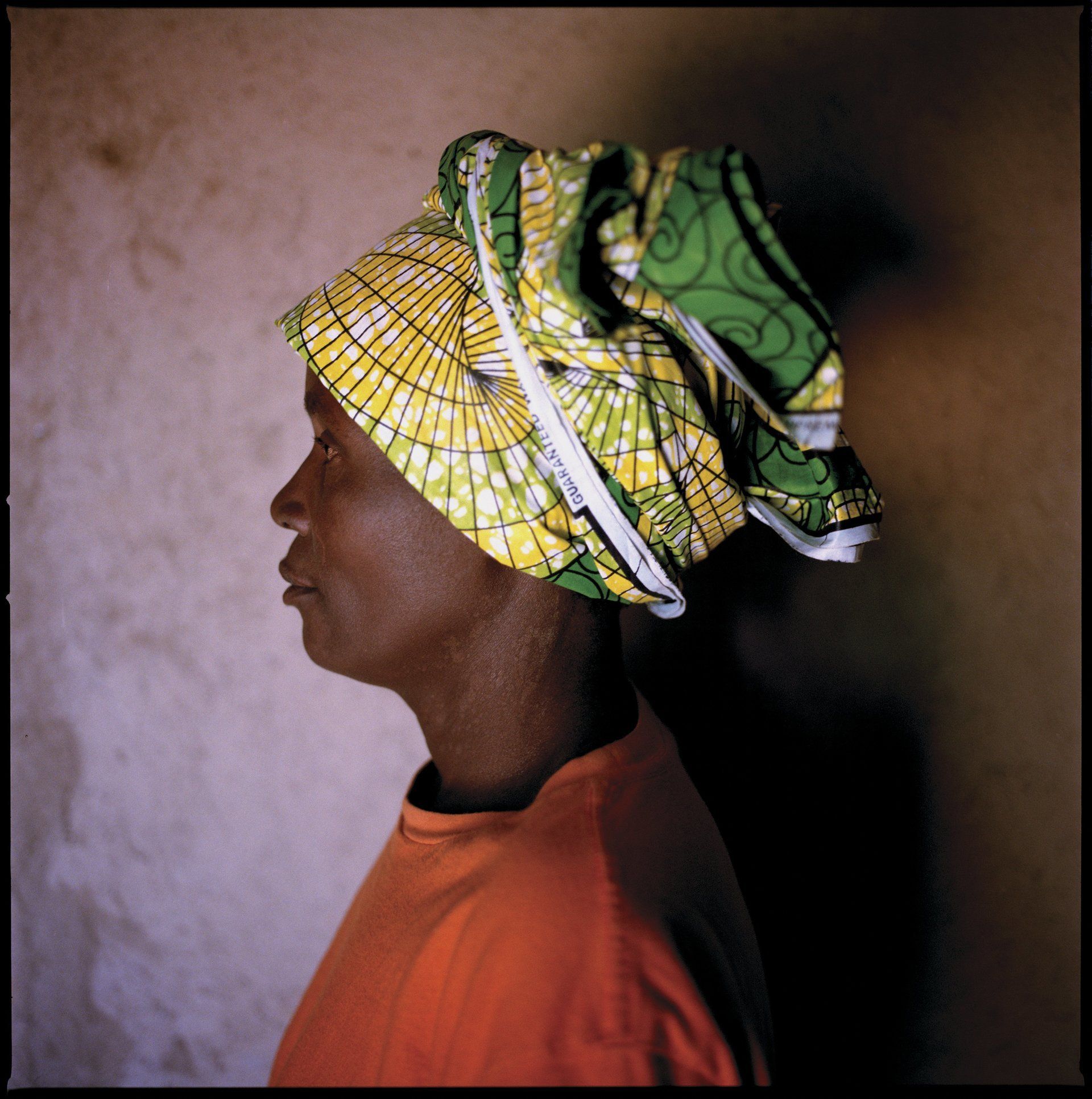 VII Foundation: Woman wearing an orange shirt with a green and yellow head wrap