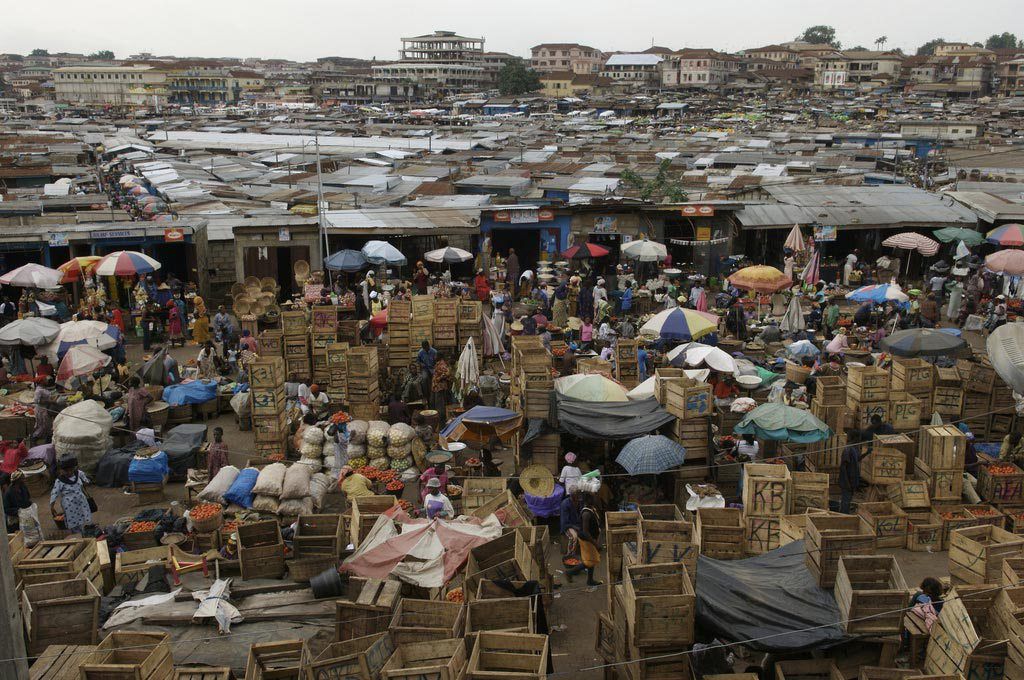 An aerial view of a market filled with lots of people and boxes