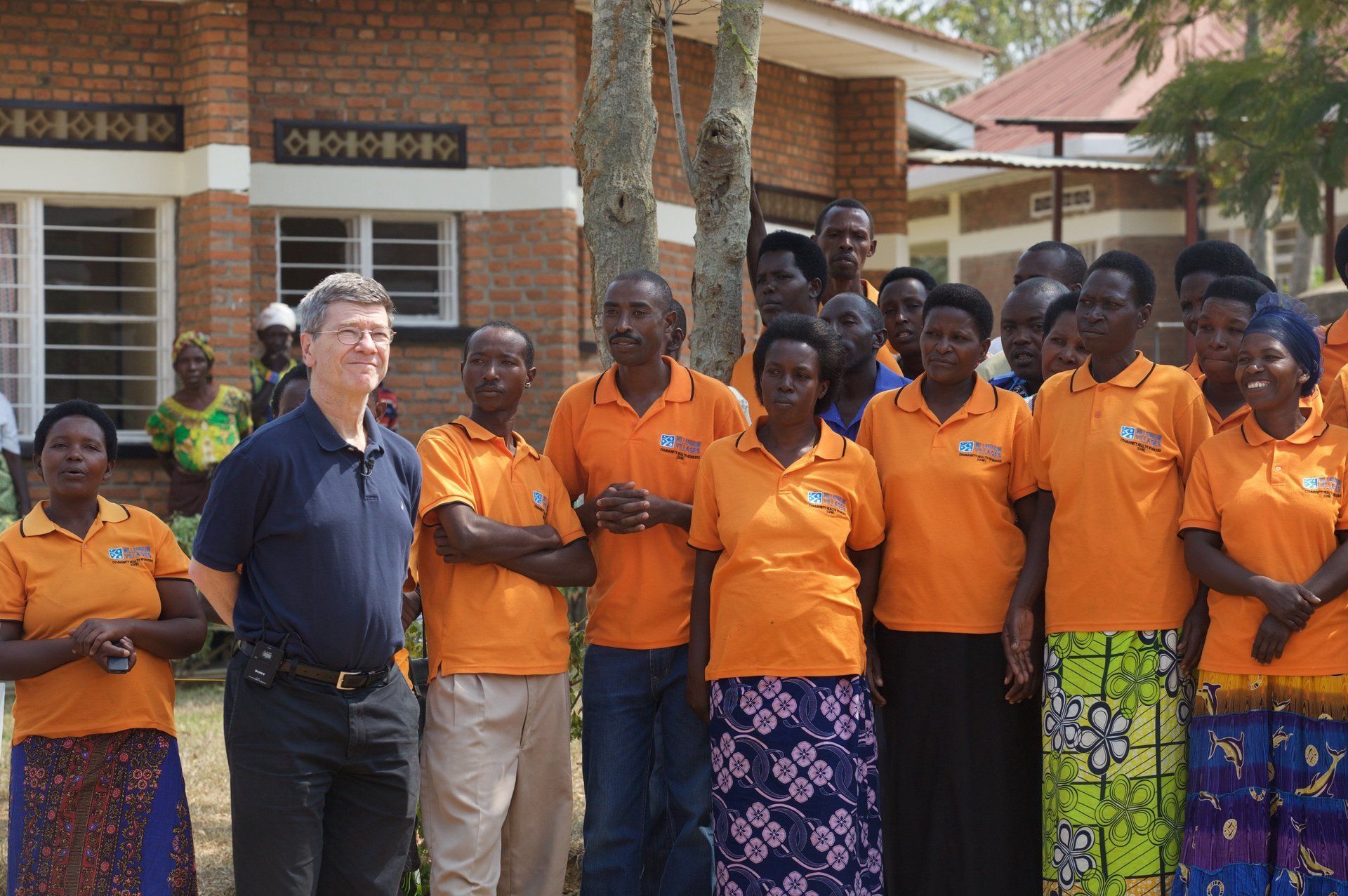Group in front of ‘MAYANGE A’ building, part of Millennium Villages Project in Rwanda, promoting sustainable development.