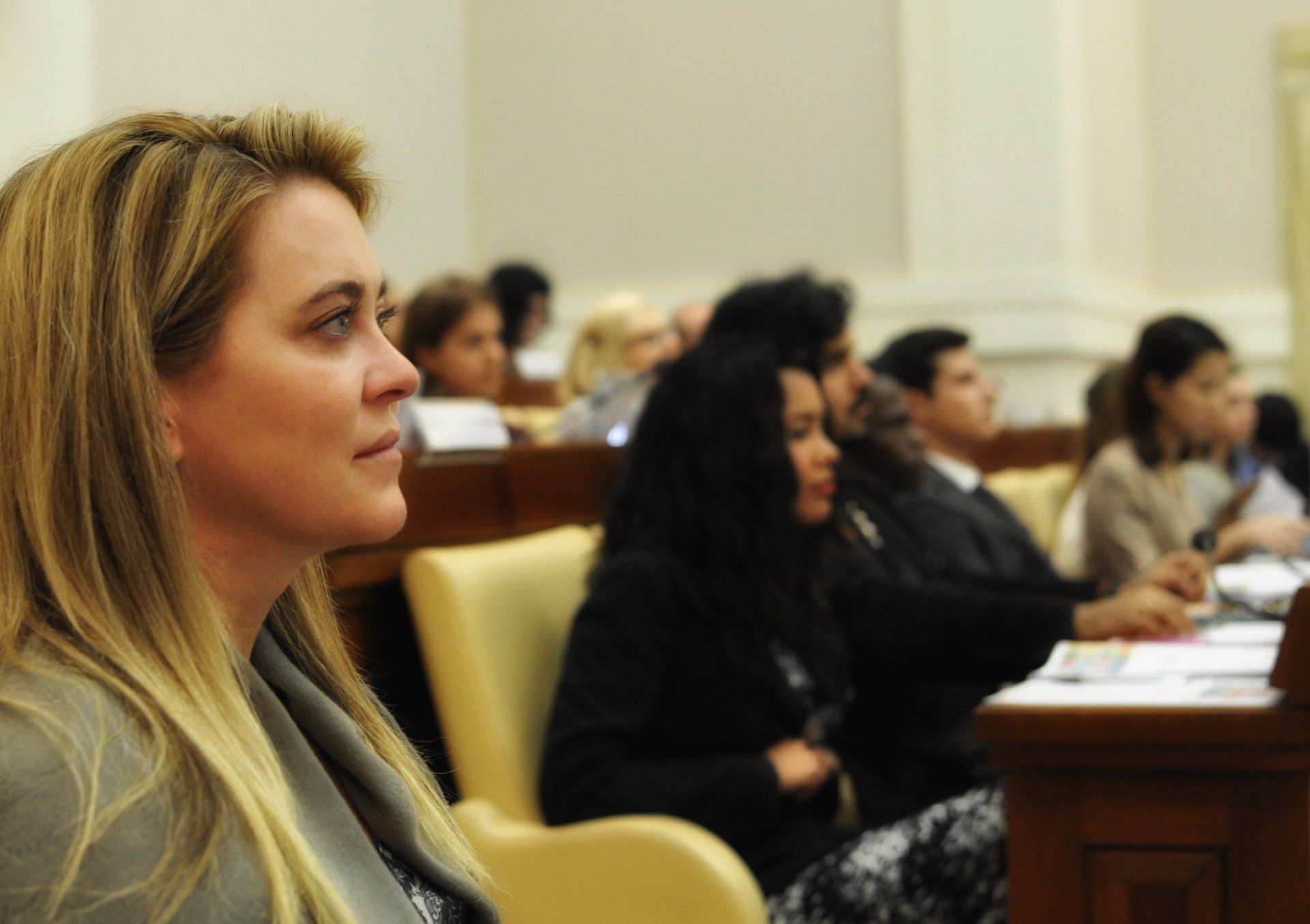 A woman sits in a classroom with other people