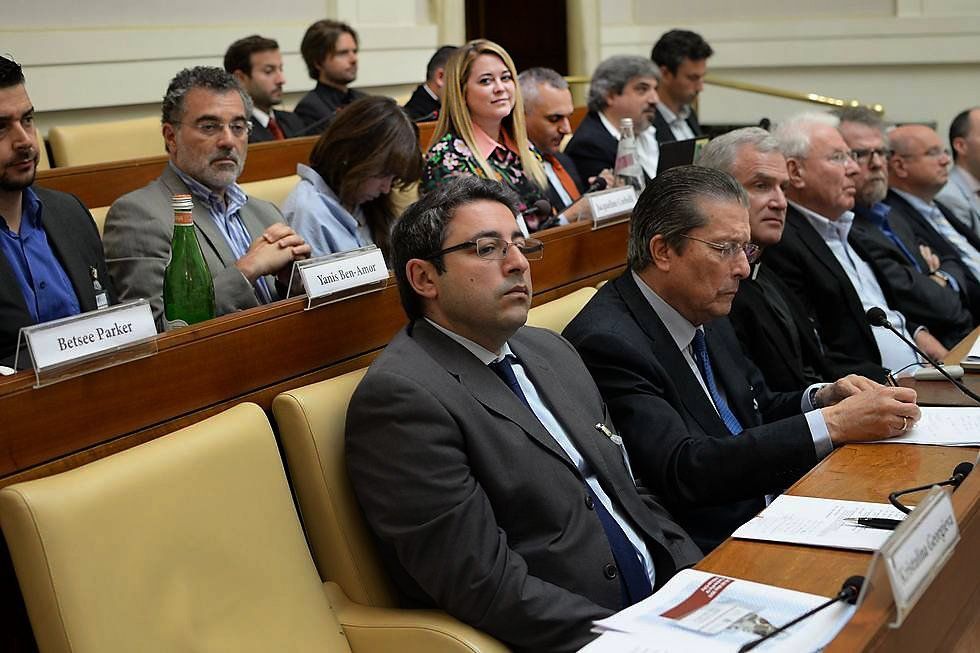 Jennifer Gross and a group of people listening to a speaker at a Ethics in Action 3: Migrants and refugees