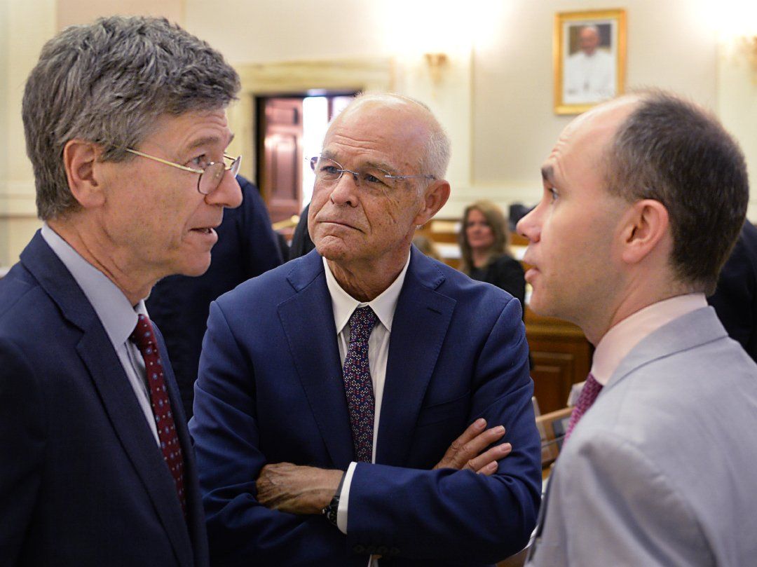 Three men talking at a Ethics in Action 3: Migrants and refugees