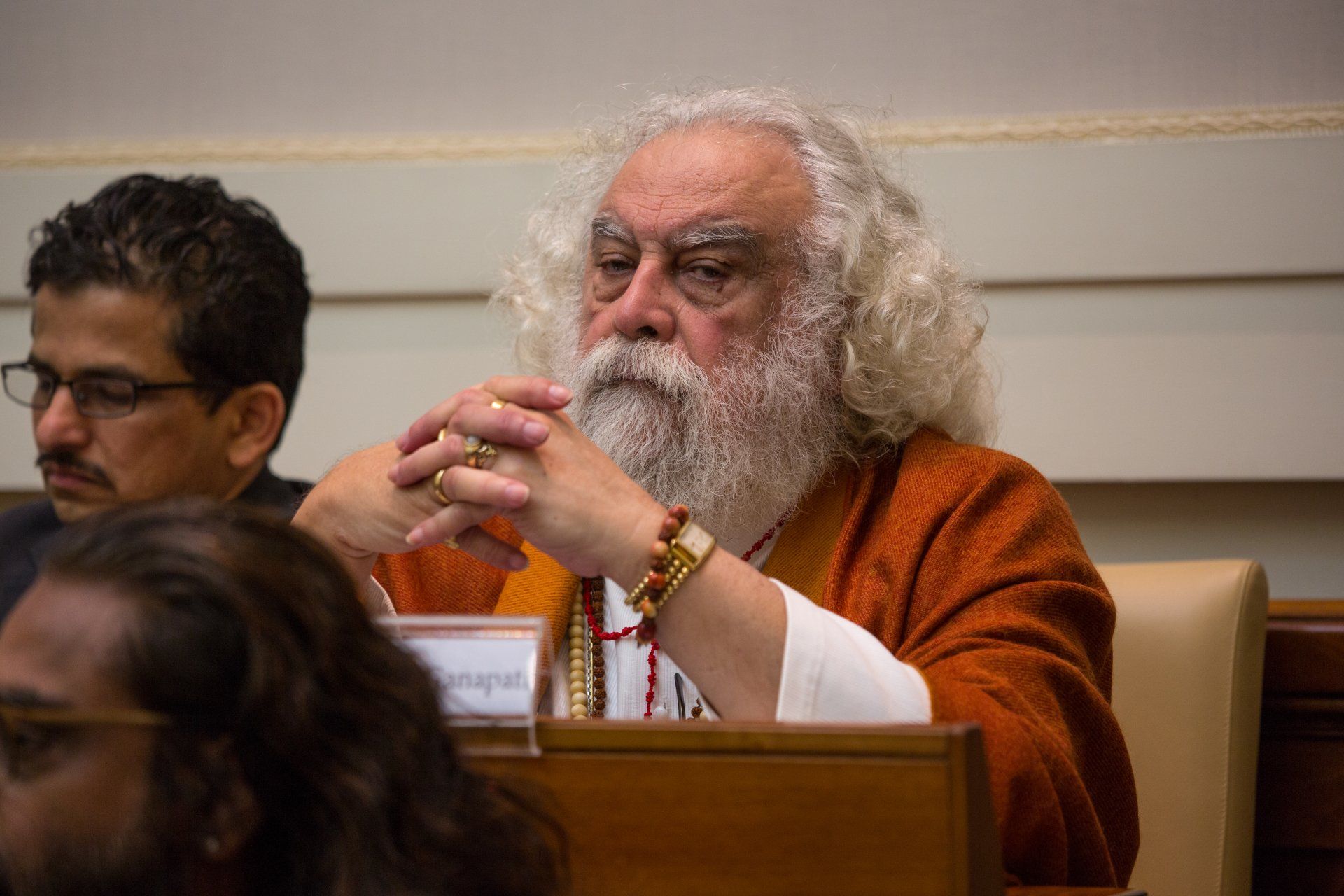 A man with a beard and long hair is sitting in a chair.