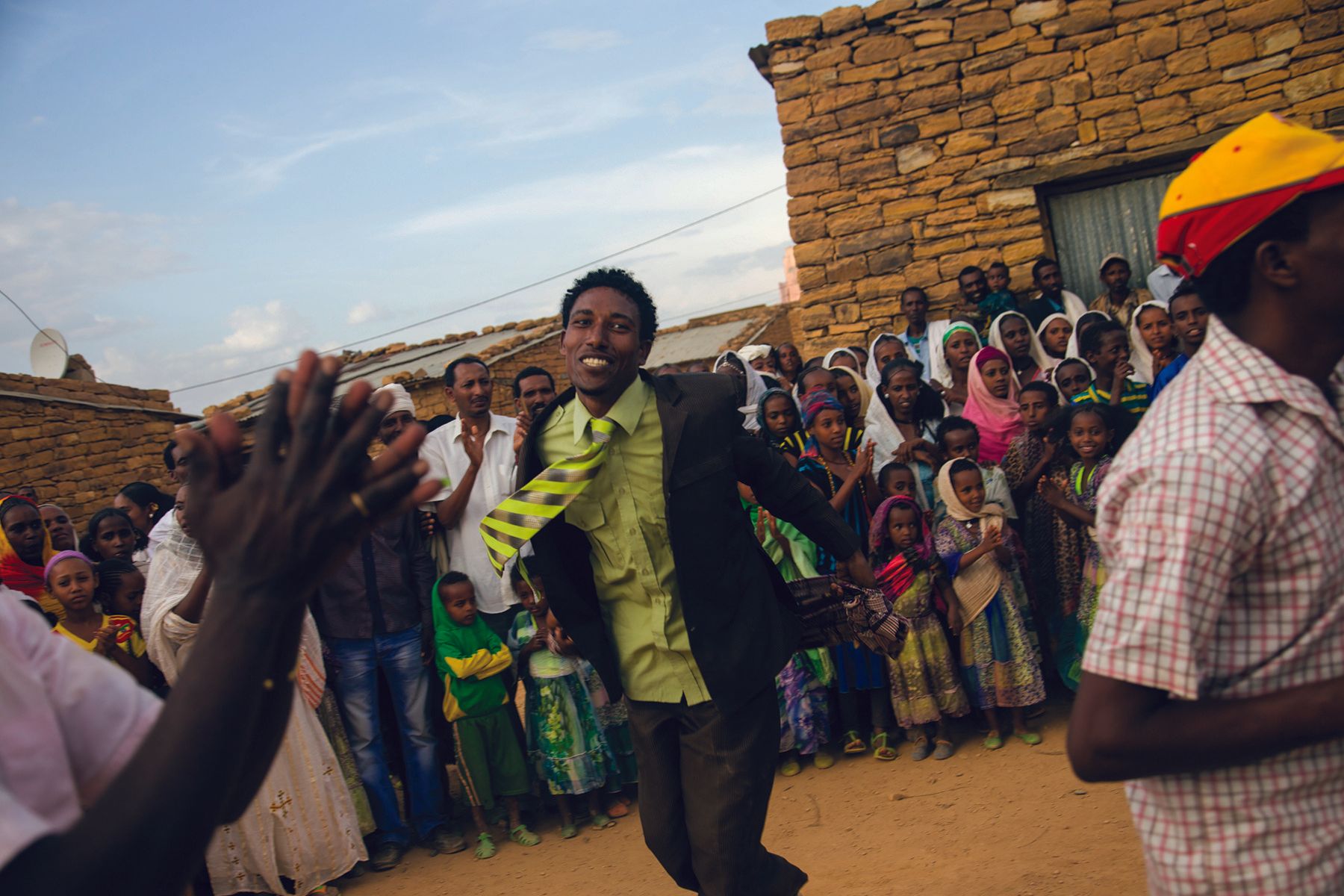 VII Foundation: A man dancing in a village surrounded by a group of people