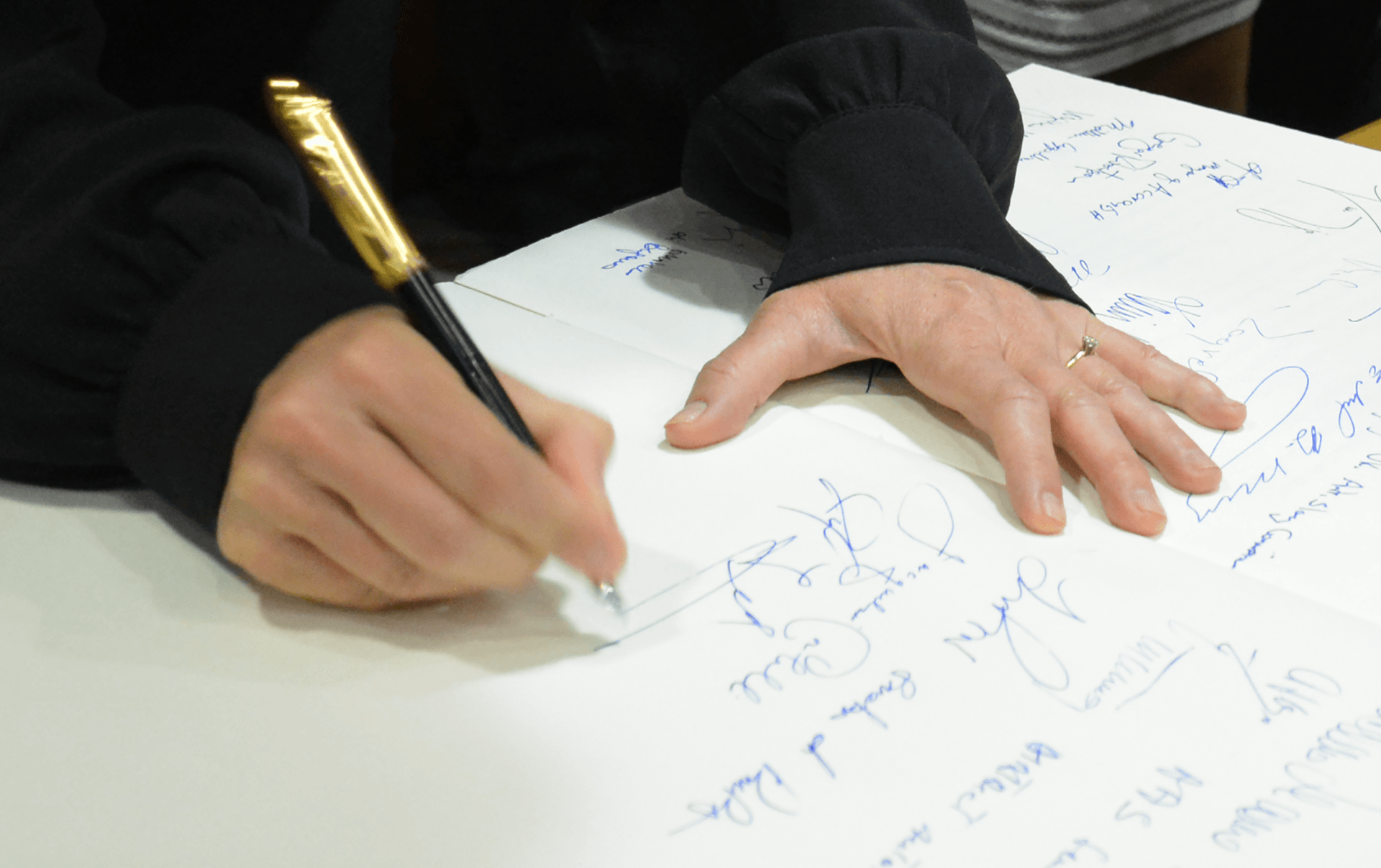 Jennifer Gross, Co-Founder of the Blue Chip Foundation,  addresses modern climate change by signing a document