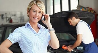 Woman Taking a call in automotive shop — Auto repair in West Chester, PA Woman Taking a call in automotive shop — Auto repair in West Chester, PA