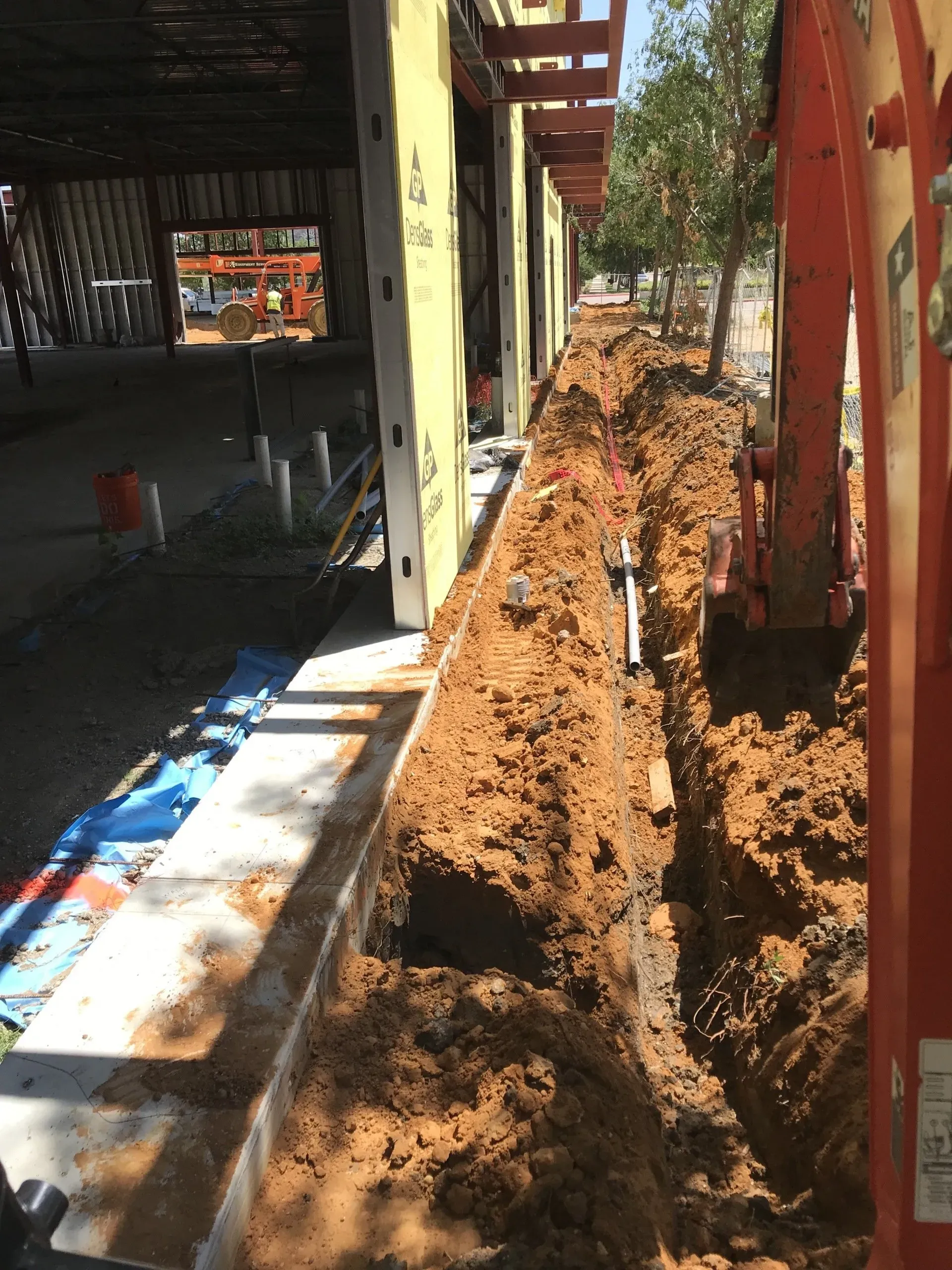 A construction site with a lot of dirt and a ladder in the foreground.