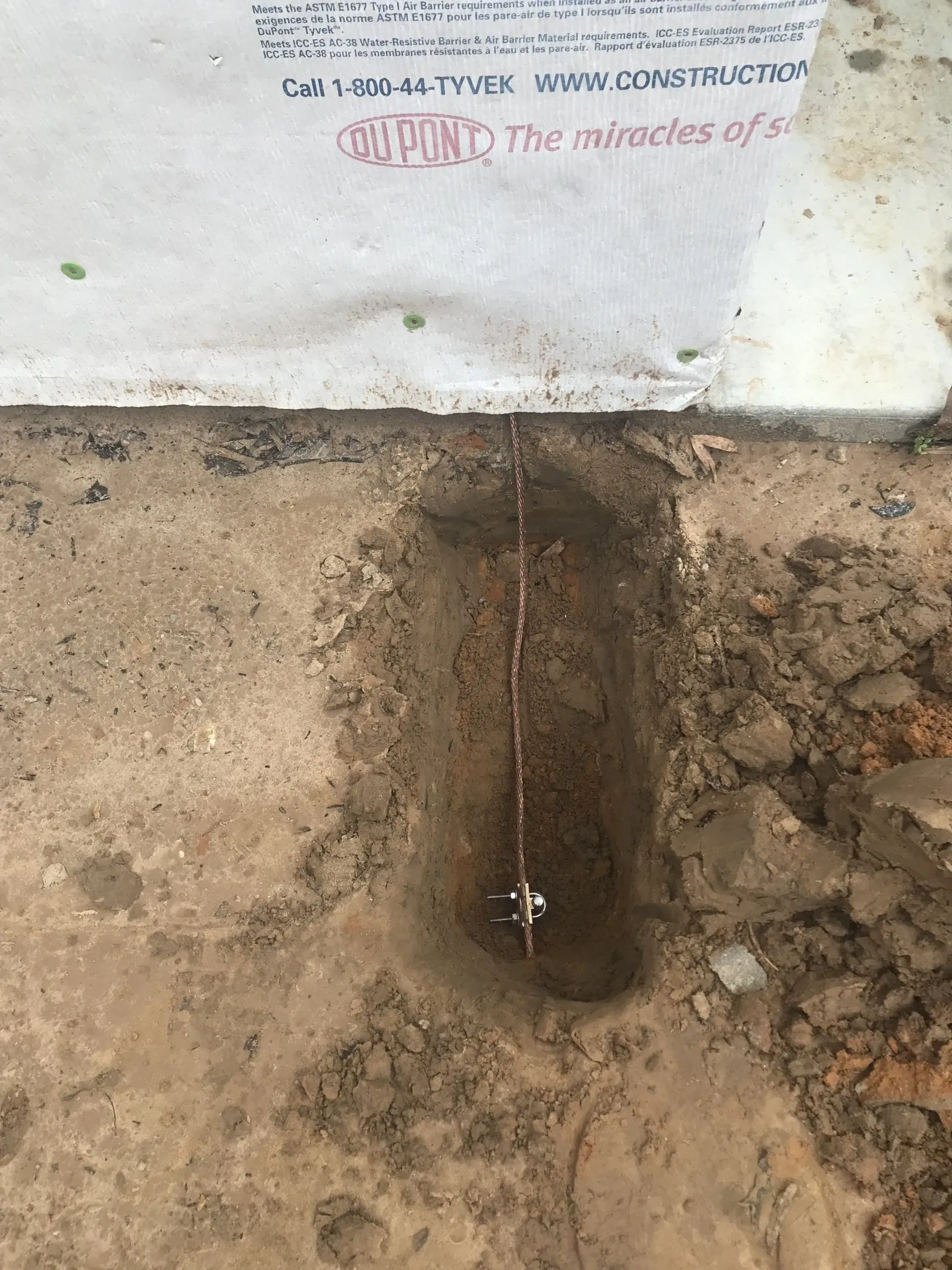 A hole in the ground with a wire sticking out of it.