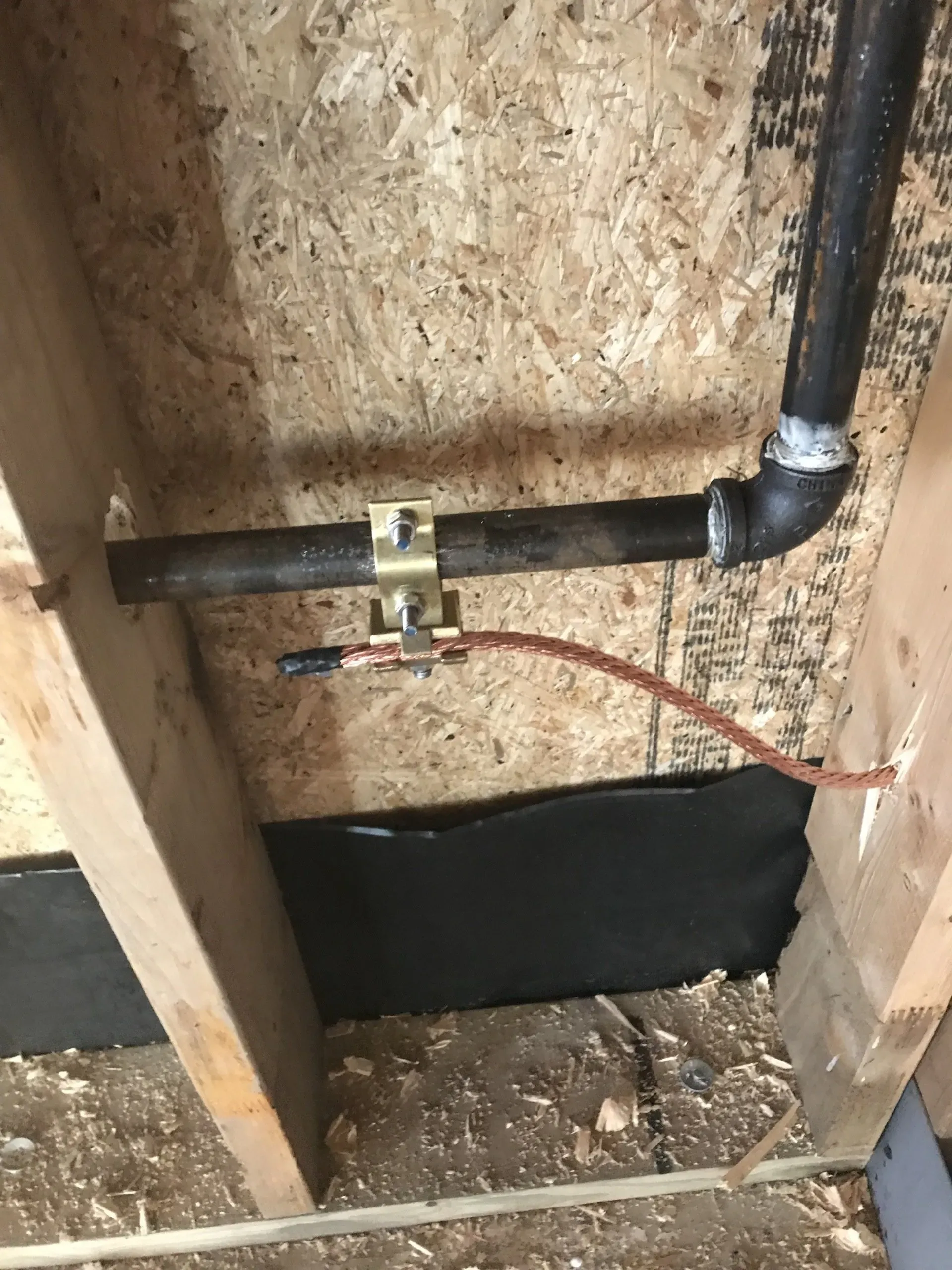 A pipe is hanging from the ceiling of a wooden building.