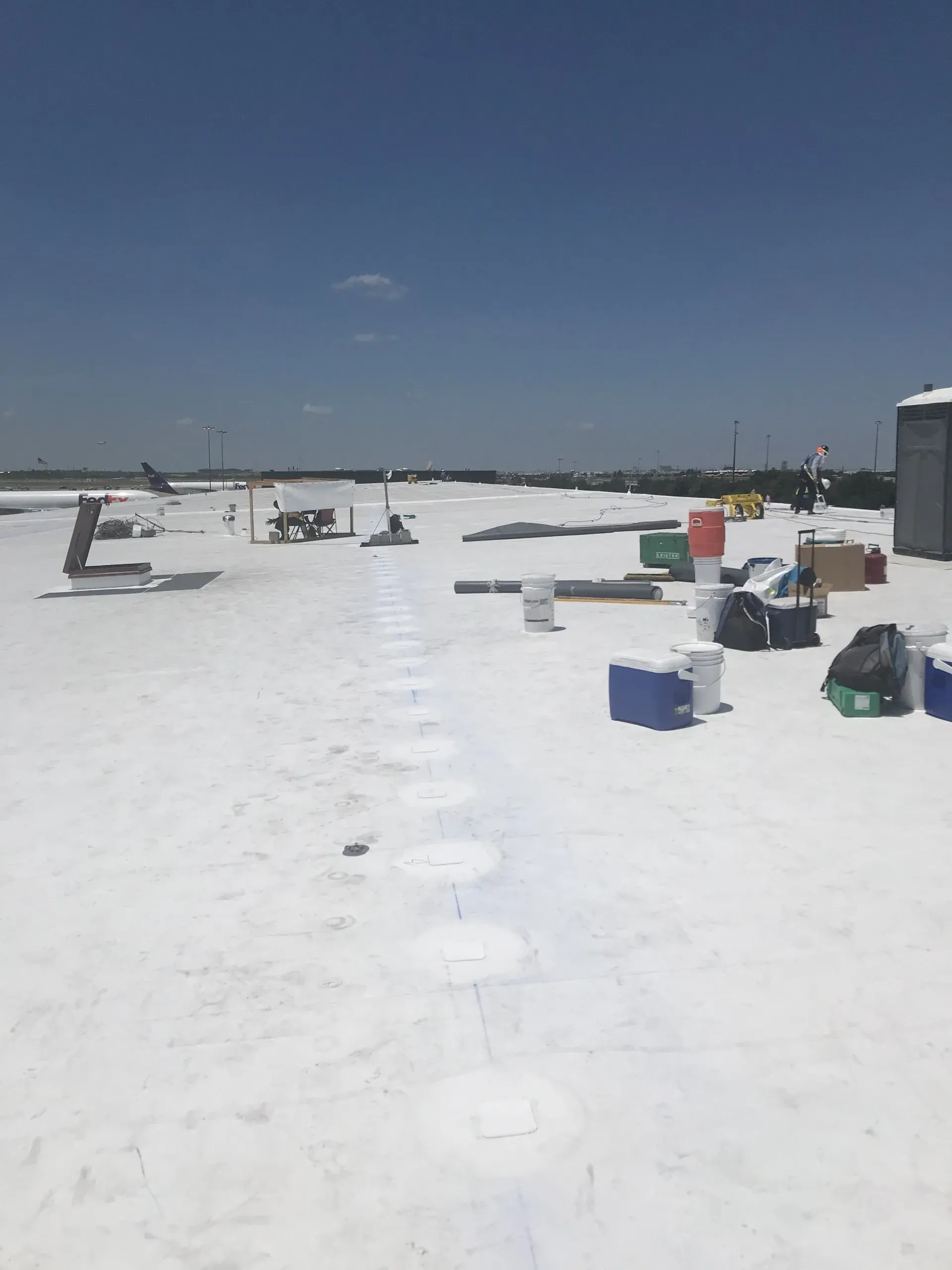 A snowy roof with buckets and coolers on it