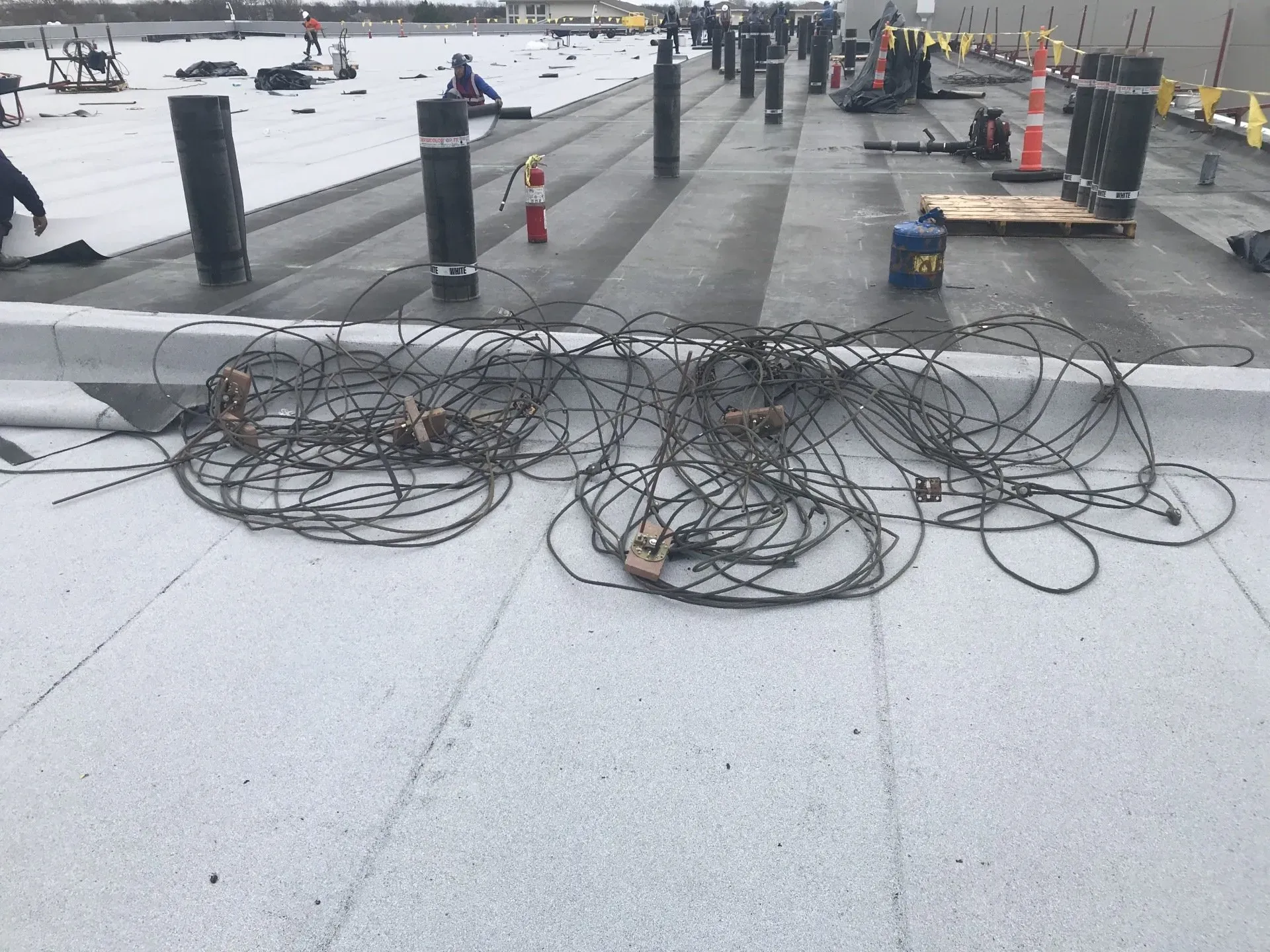 A bunch of wires are laying on the ground on a roof