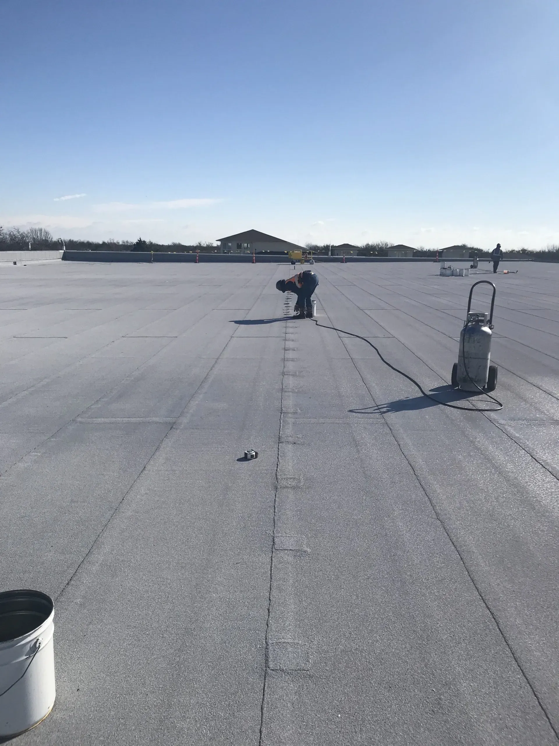 A bucket and a vacuum cleaner are on the roof of a building.