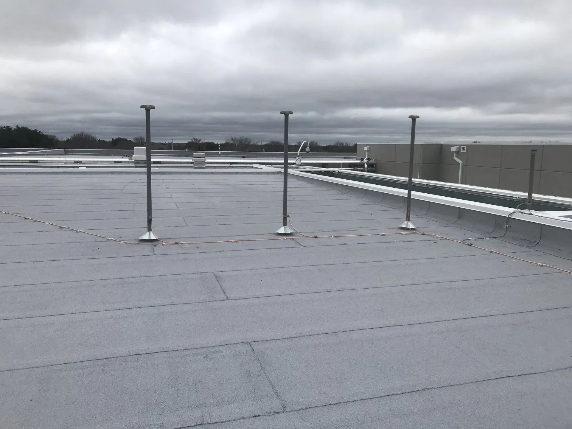 The roof of a building with a cloudy sky in the background