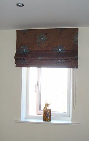Brown roman blind with blue sequins and flower patterns