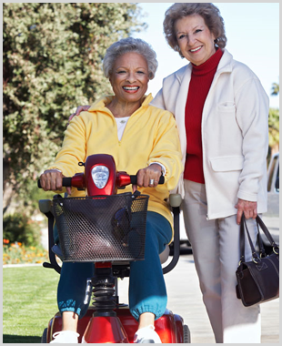 For mobility scooters on the Isle of Wight, call Coastal Mobility on 01983 866 431 or 01983 533 500 Lady sat in a scooter with a friend standing next to her