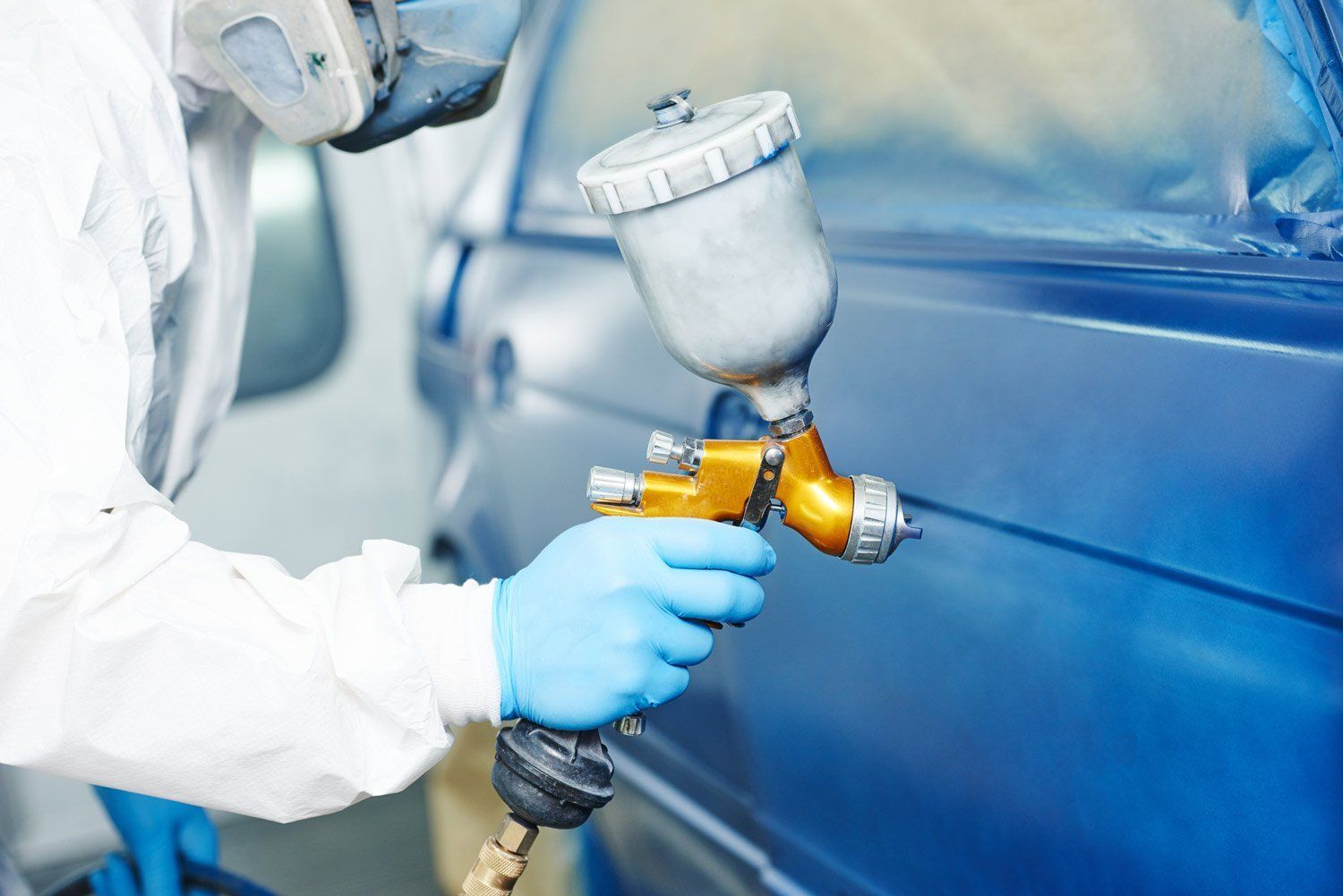 man painting car blue