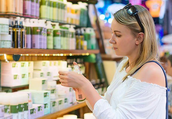 Young woman choosing cosmetic cream in beauty shop