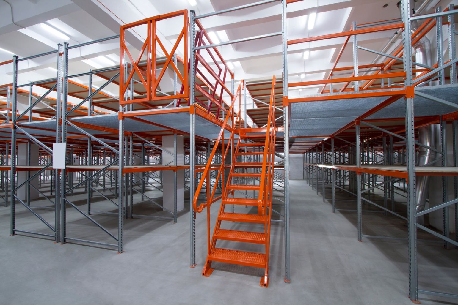An empty warehouse with stairs leading up to the second floor