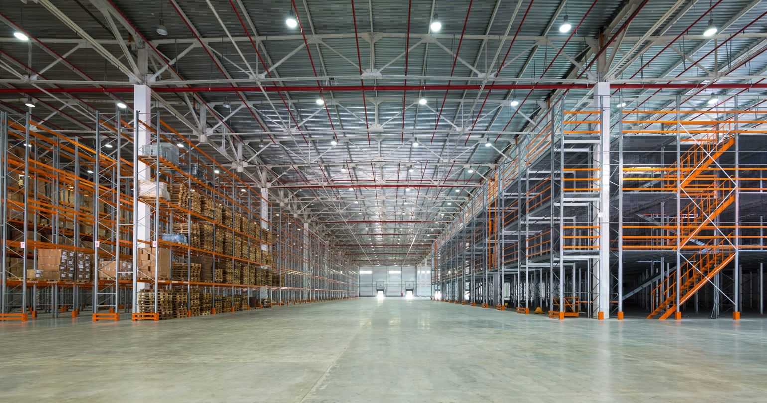 An empty warehouse with lots of shelves and stairs.