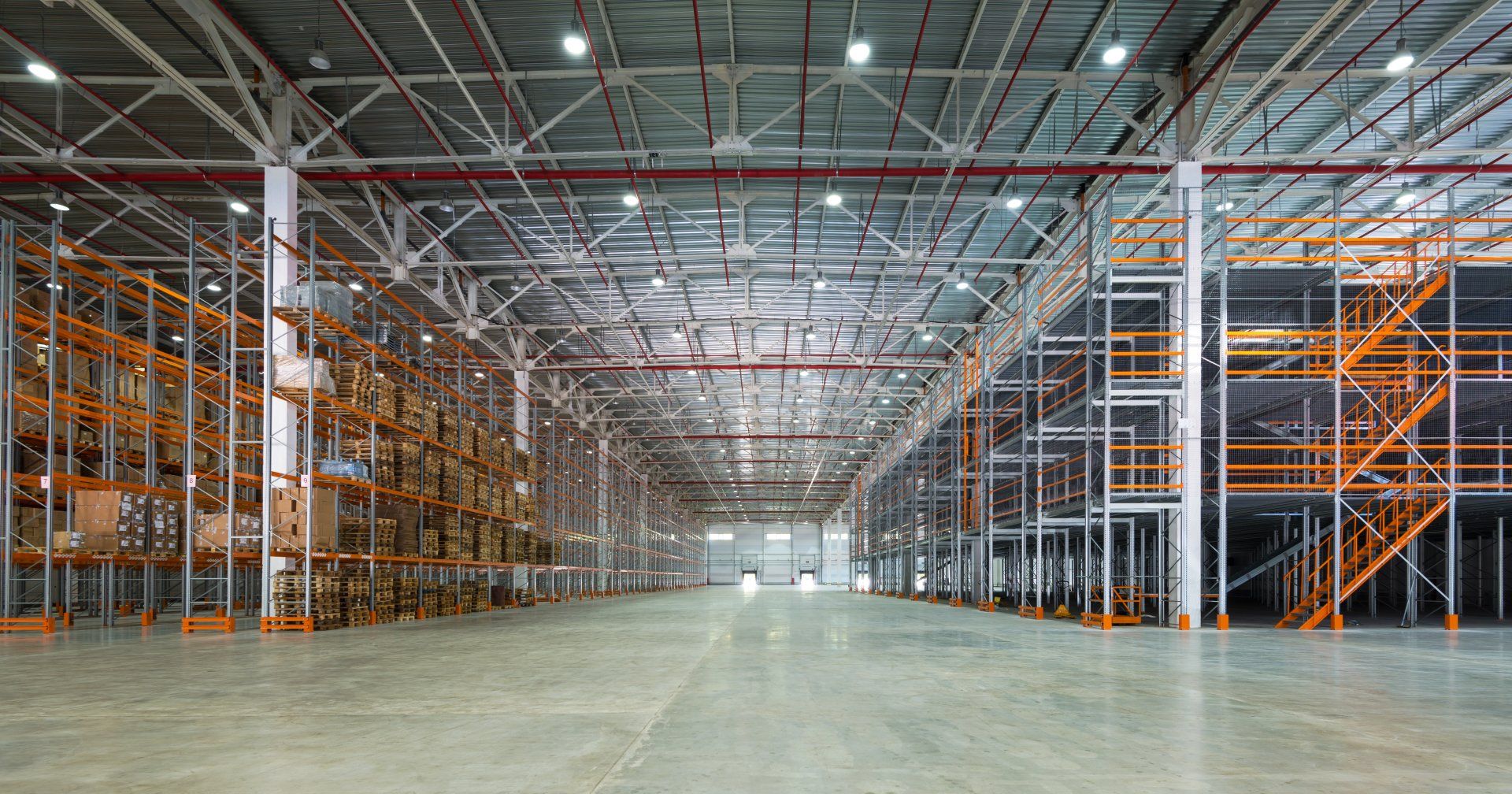 An empty warehouse with lots of shelves and stairs.