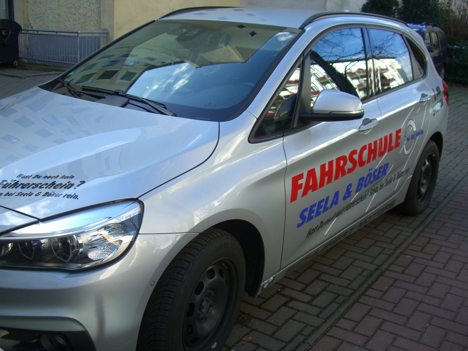 Ein silbernes Auto mit dem Wort Fahrschule auf der Seite