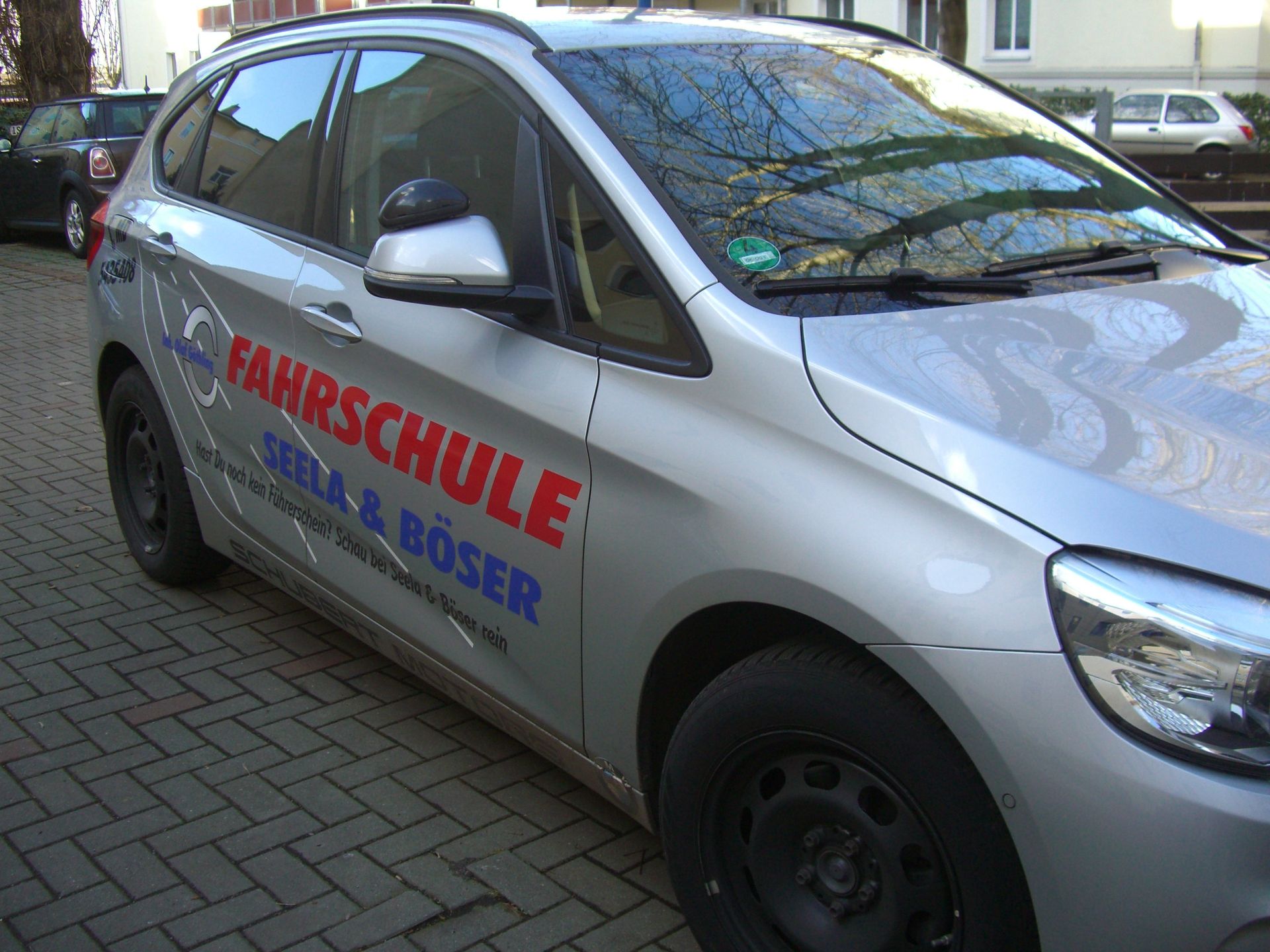 Ein silbernes Auto mit dem Wort Fahrschule auf der Seite