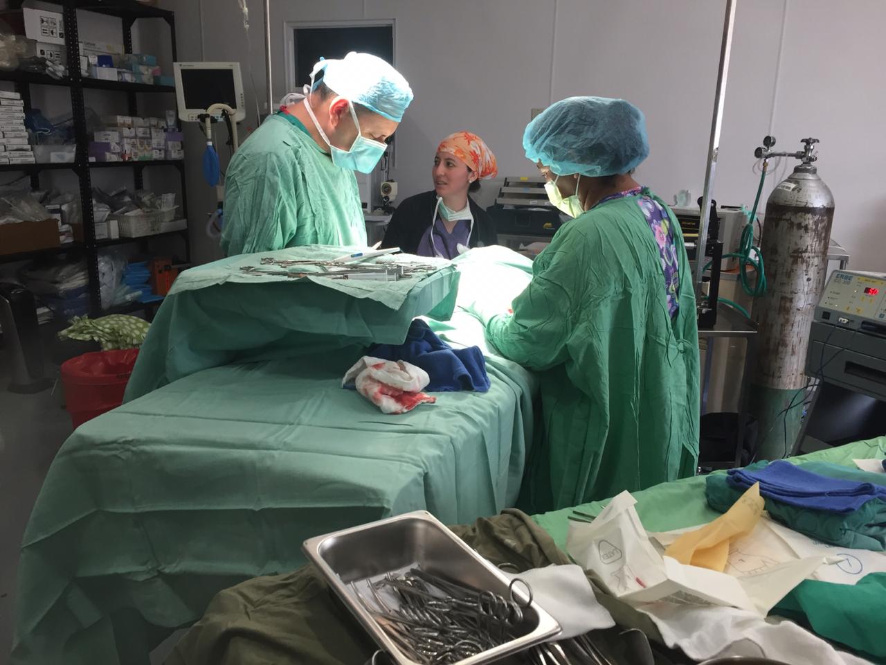 Chirurgen in OP-Kleidung operieren einen Patienten unter sterilen Bedingungen im Operationssaal.