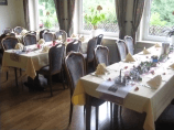 Ein Esszimmer mit Tischen und Stühlen, aufgestellt für eine Party.