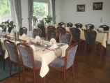 Ein Esszimmer mit Tischen und Stühlen, aufgestellt für eine Party.