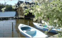 Ein paar Boote liegen am Ufer eines Sees.