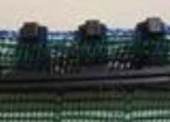 Dark green and black blurred rows of machinery or equipment in an industrial setting
