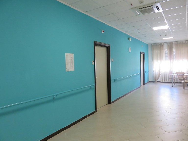 corridoio di una casa di riposo con parete azzurra