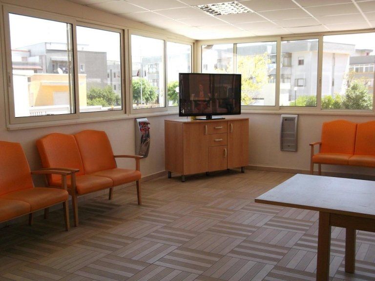 veranda di una residenza per anziani con tv e sedie