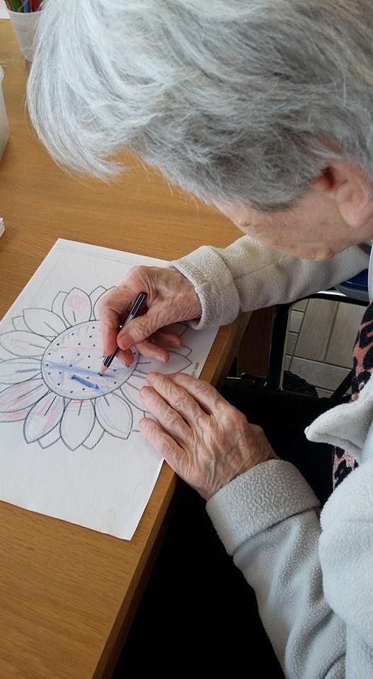 donna anziana che disegna un fiore