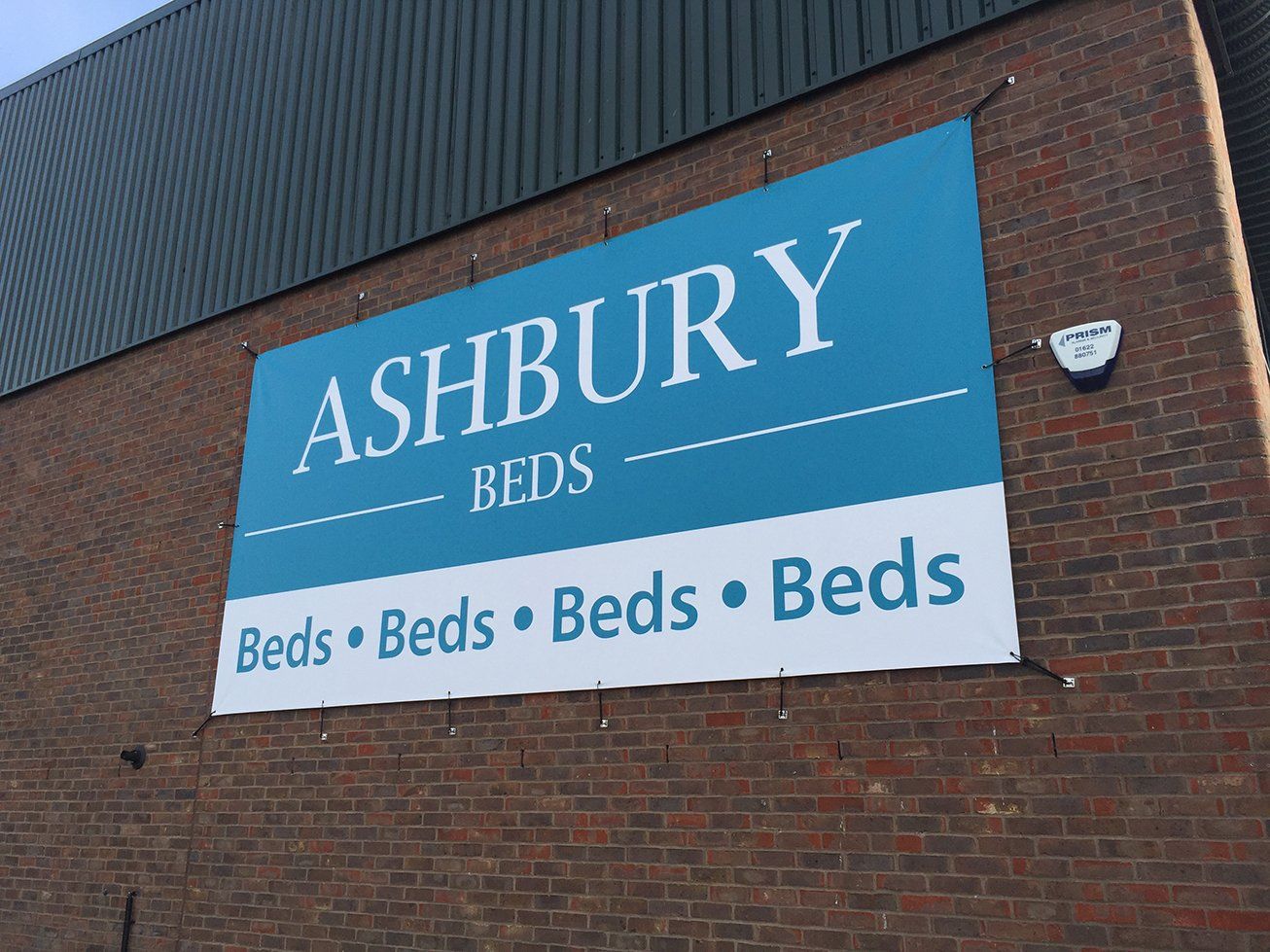 Large PVC banner mounted to wall using bungees