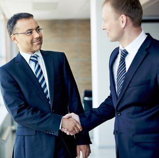 Two men in suits and ties, shaking hands