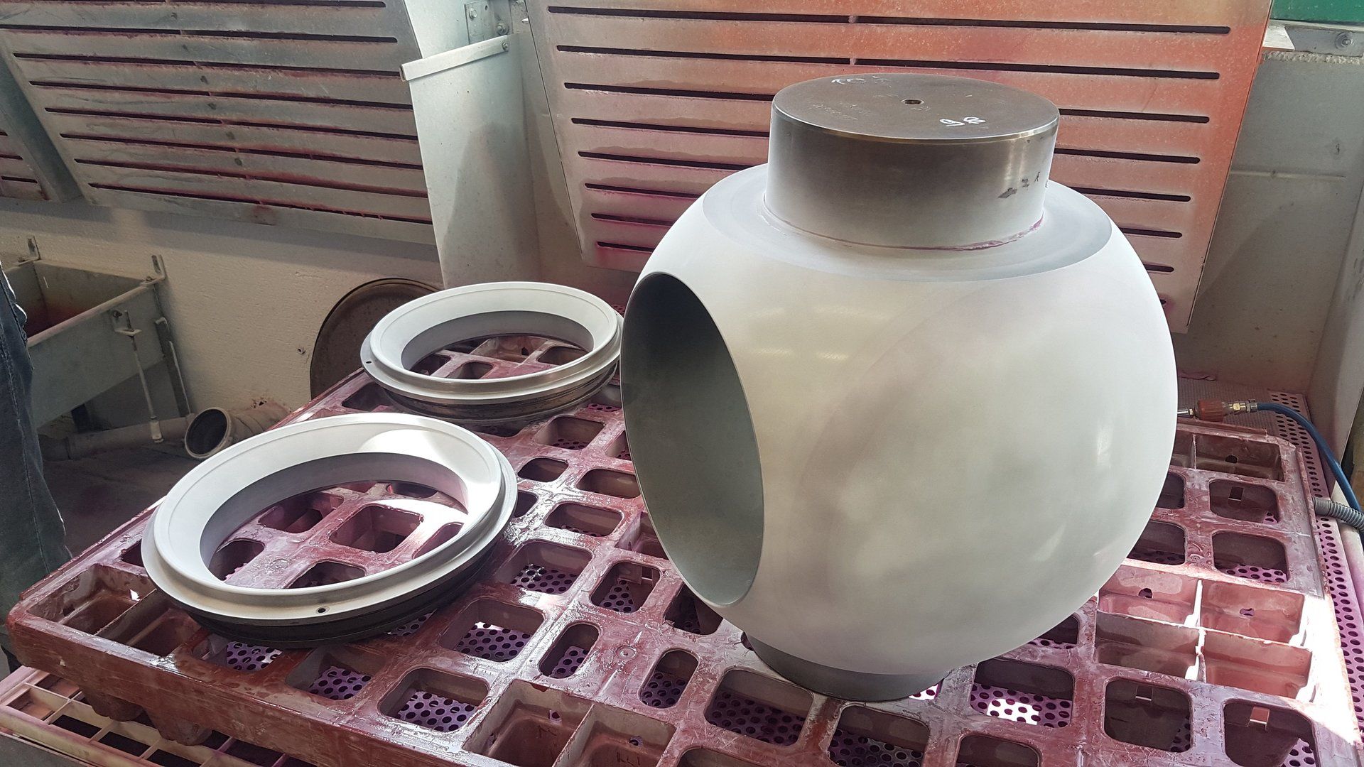 Un grande oggetto metallico è appoggiato su un vassoio di plastica.