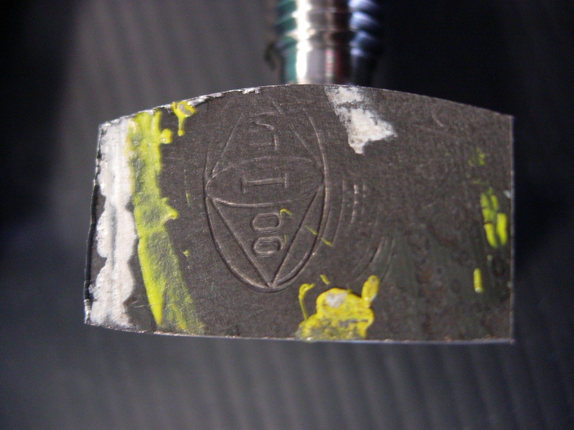 Un primo piano di un pezzo di metallo con un logo sopra