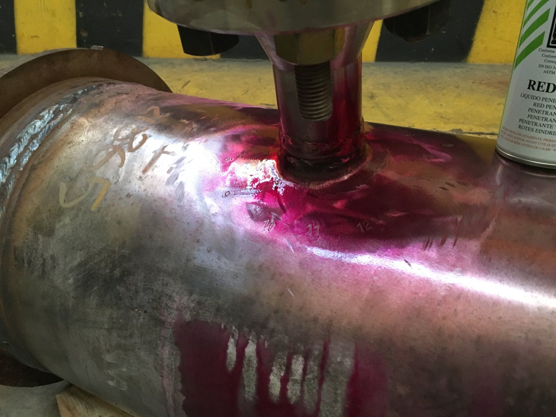 Primo piano di un tubo metallico con una bomboletta di vernice spray accanto.