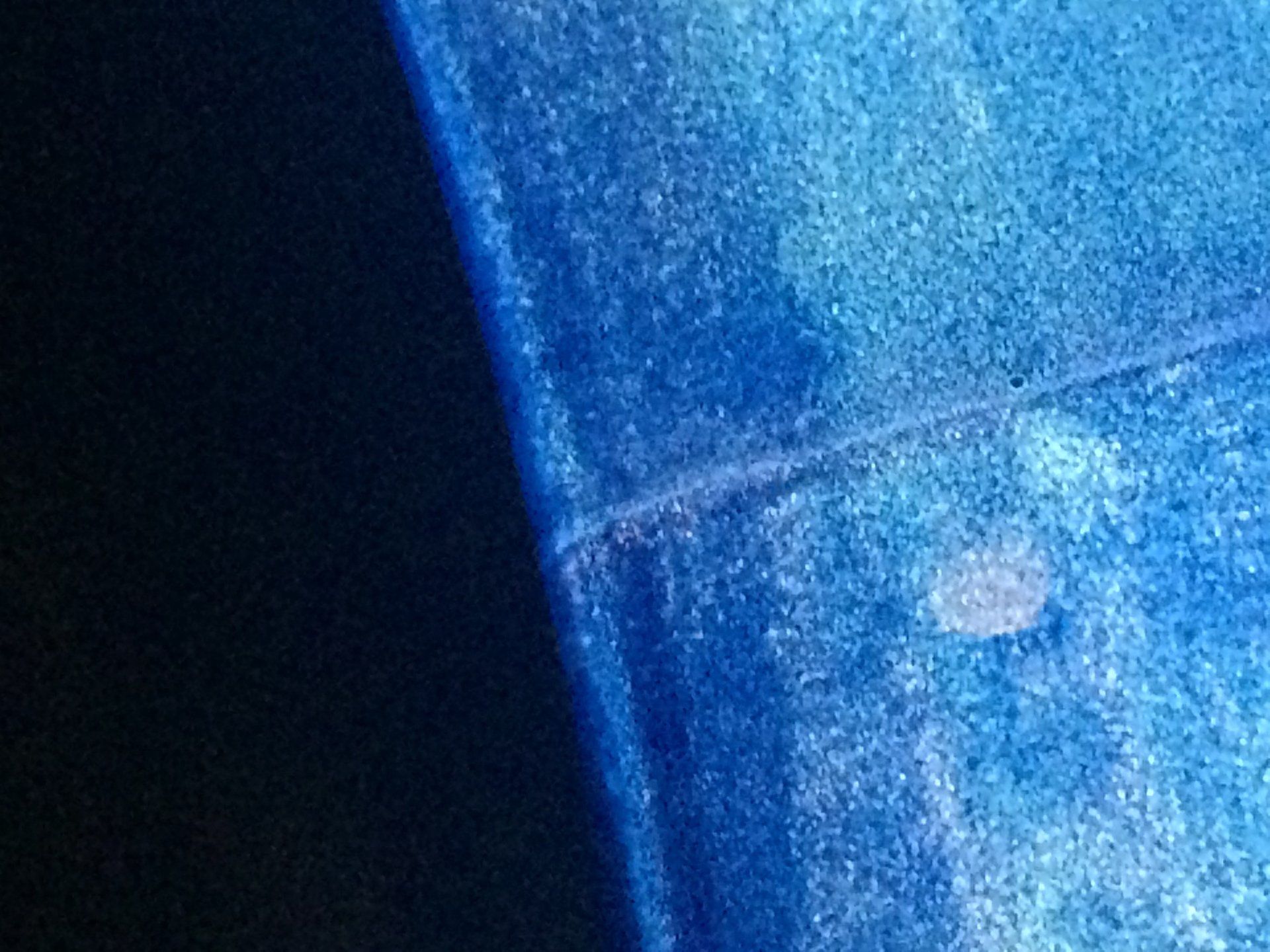 Un primo piano di una superficie blu con uno sfondo nero.